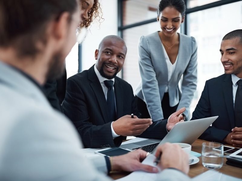 Shot of a group of businesspeople discussing something on a laptop